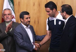 Iran's president meets victorious football team, presents it with gifts