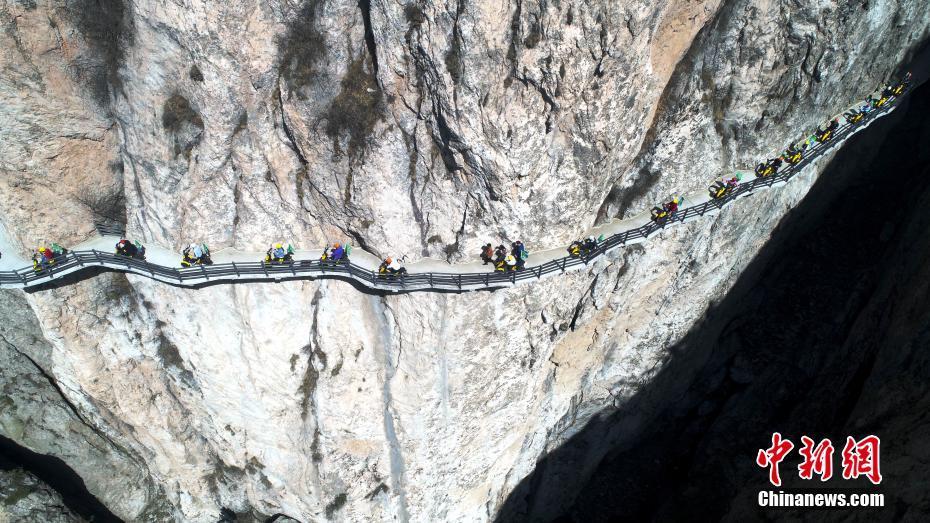 Волонтеры проехали на электромопедах по нависающему над пропастью мосту в Китае (ФОТО)