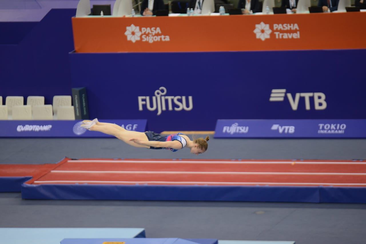 Борьба за медали - лучшие моменты третьего дня Всемирных соревнований среди возрастных групп по прыжкам на батуте и тамблингу в Баку (ФОТО)